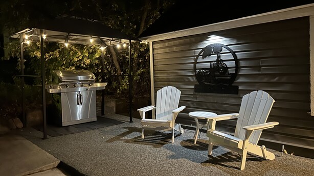 An outdoor patio with a grill, two Adirondack chairs, and a table. - Downtown Taber Street Railroad 🚂 House - Great Location!! (Williams)