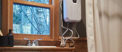A wooden bathroom with a window, a sink, a towel rack, and a shower curtain.