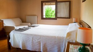 A bedroom with a bed, a window, a radiator, and a lamp. - Laura's House (Castelcucco)
