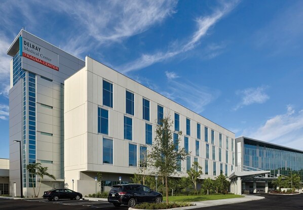 A modern medical center building with a clear sky.