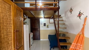 A room with a wooden ceiling, a hammock, a staircase, and a kitchen area. - Casas Vasconcelos (Itacaré)