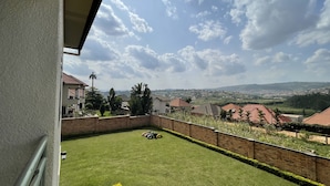 A residential area with a well-maintained lawn, brick walls, and houses with red roofs. - Captivating 7-bed House in Kigali, Rwanda (Kigali)