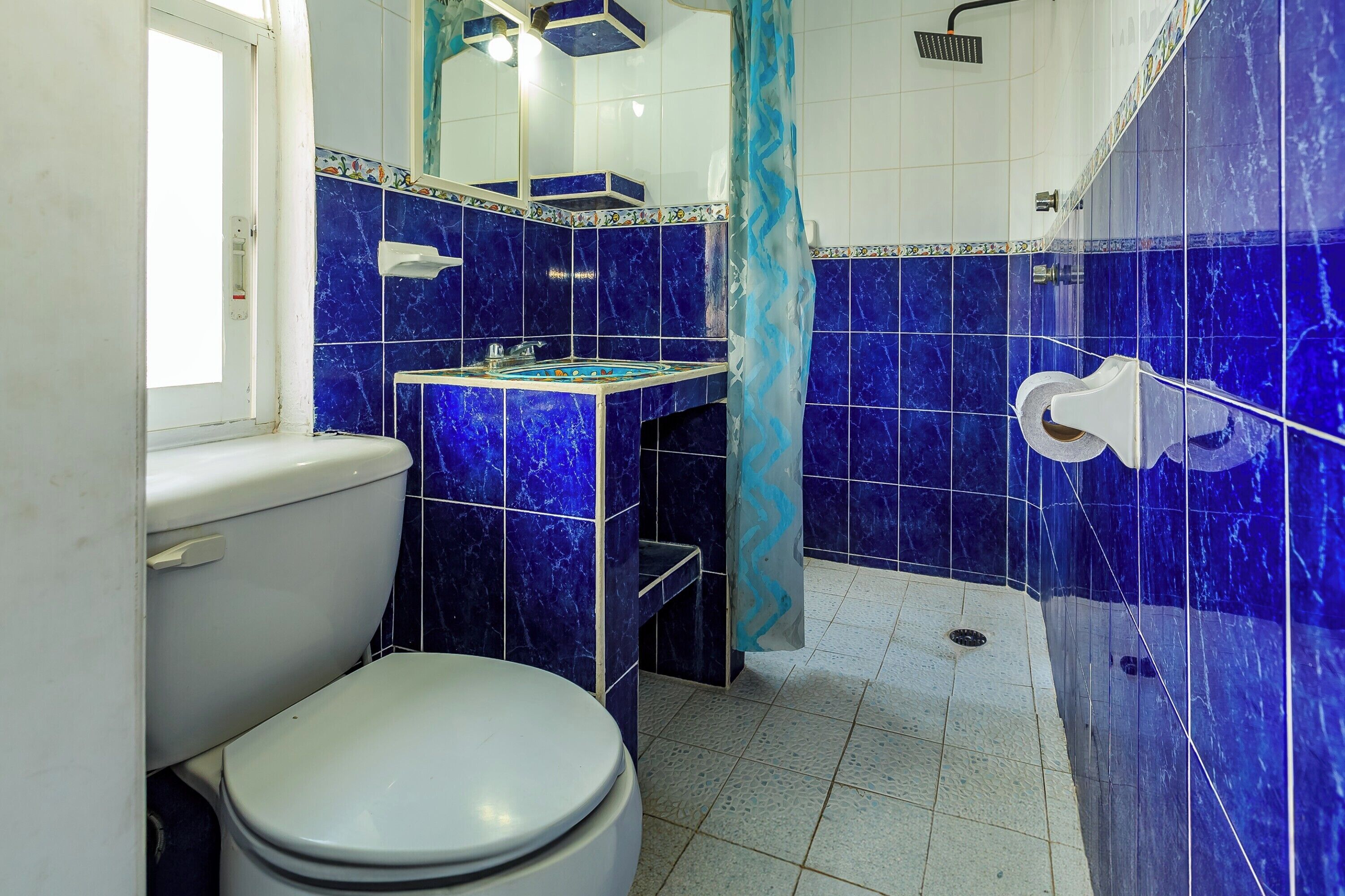 A bathroom with a toilet, sink, and shower area.