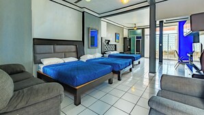 A hotel room with three beds, a ceiling fan, and a view of the outside. - OYO Casa Mission (Puerto Vallarta)