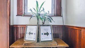 A wooden table with two framed signs indicating directions to apartments #6 & #8 and #3 & #2. - Historic Apartment in Downtown Seward (Seward)