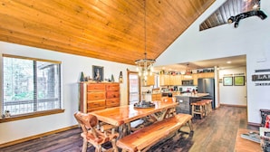 A spacious kitchen with wooden cabinets, a central island, and a dining area with a wooden table and benches. - Pinetop Retreat w/ Fire Pit & Game Room! (Pinetop)