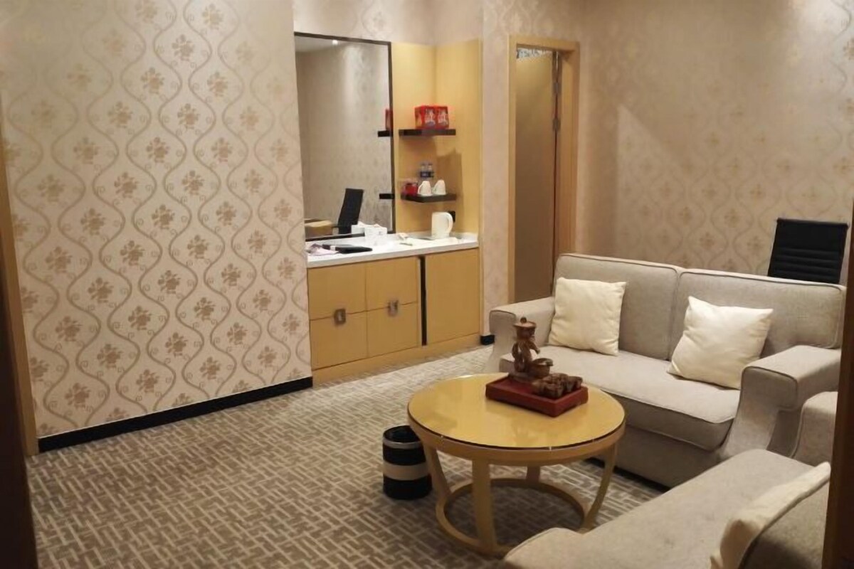 A living room with a sofa, a coffee table, and a cabinet with shelves.