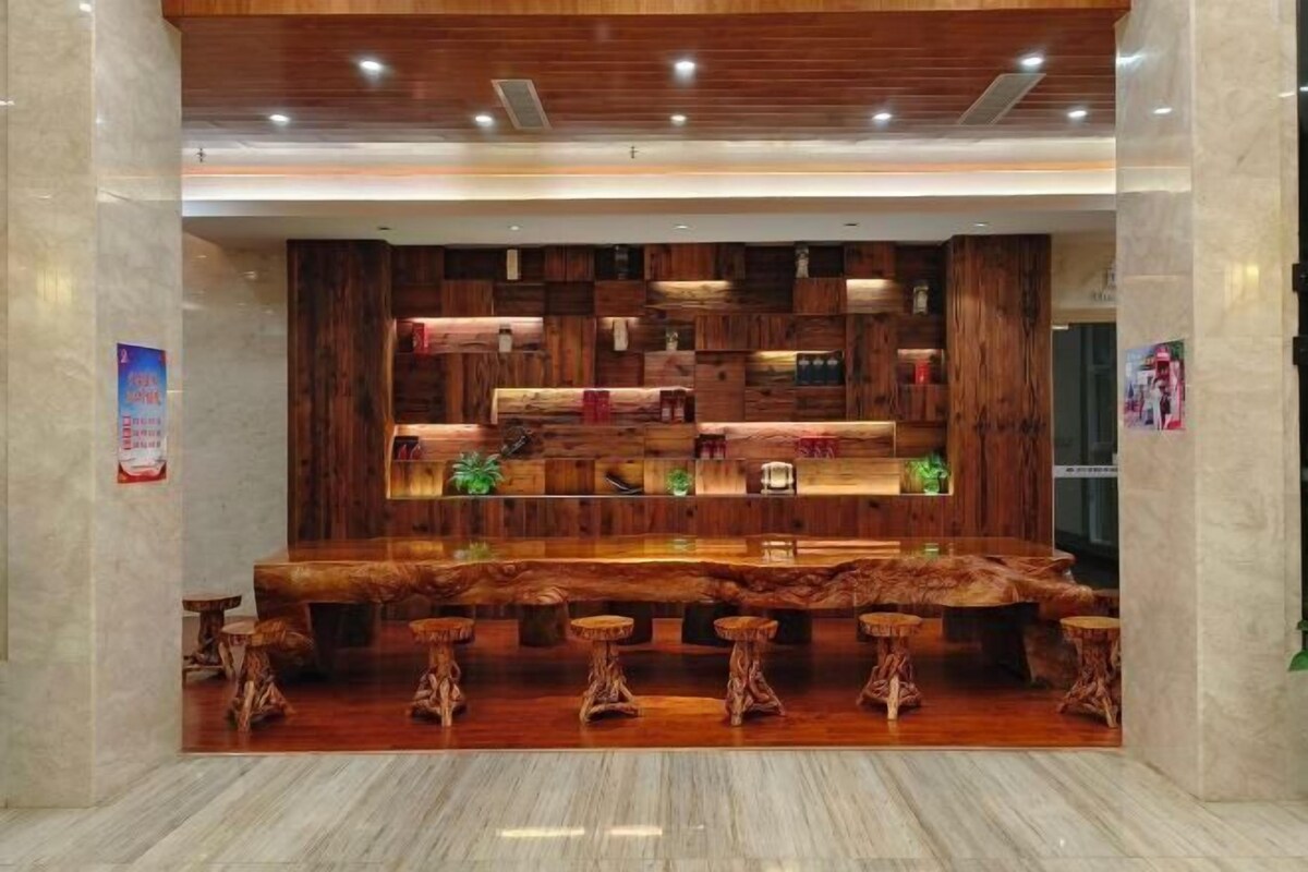 A bar area with a wooden bar counter and stools.