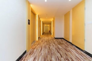 Pasillo de hotel con piso alfombrado y puertas a ambos lados.