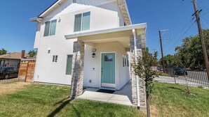 A two-story house with a stone pillar, a green door, and a small porch. - Close to Sac DT🏨 Charming&Cute 🛌Brand New House😊 (Sacramento)