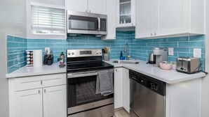 A modern kitchen with white cabinets, a stainless steel microwave, a black stove, and a dishwasher. - Close to Sac DT🏨 Charming&Cute 🛌Brand New House😊 (Sacramento)