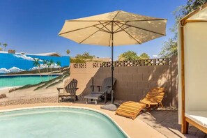 A swimming pool area with lounge chairs, an umbrella, and a mural of a beach scene. - Heated Pool/Hot tub in heart of Tempe/ASU/Scottsdale (Tempe)