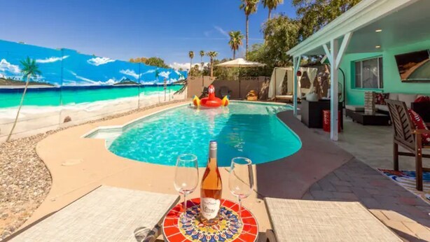 A pool area with a view of the beach, a lounge chair, and a table with a bottle and glasses. - Heated Pool/Hot tub in heart of Tempe/ASU/Scottsdale (Tempe)