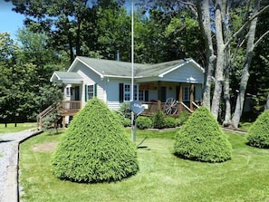 Une maison avec un porche, une boîte aux lettres et un jardin bien entretenu.