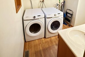 Twee Samsung voorladers in een wasserij met een wasbak en houten vloeren.