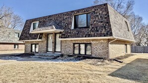 A modern two-story house with a brick exterior and large windows. - Remodeled apartment in central location (Council Bluffs)