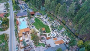 Vista aérea de un resort con piscina, habitaciones de huéspedes y zona de estacionamiento.