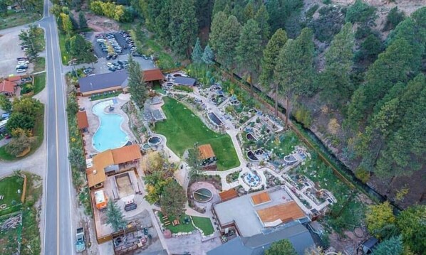 An aerial view of a resort with a swimming pool, guest rooms, and a parking area. - Epic Mountain Chalet – Jaw-Dropping 180° Views! (Durango)