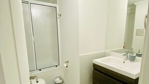 A bathroom with a toilet, sink, and mirror.