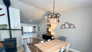 Une cuisine moderne avec des meubles blancs, un îlot central et une cuisinière intégrée.