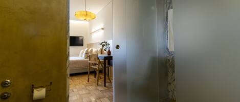 Un baño moderno con puerta de madera, inodoro y lavamanos.