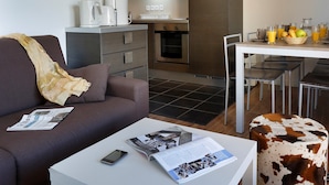 Una sala de estar moderna con un sofá, una mesa de centro y una zona de comedor con una mesa y sillas.