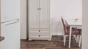 A kitchen with a white refrigerator, a white cabinet, and a dining table with chairs. - Holiday apartment with sea view, air conditioning and close to the beach (Klimno)