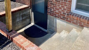A brick exterior with a dark door, a small porch area, and a window. - Your cozy riverfront escape with big-city access (Council Bluffs)