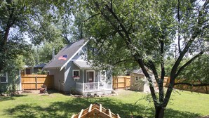 Une propriété résidentielle dotée d’un patio couvert, d’une clôture en bois et d’une pelouse.