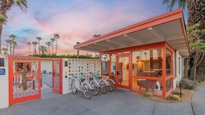 A modern building with a glass facade, a covered entrance, and a bike parking area. - Mojave Resort - Adults Only (Palm Desert)