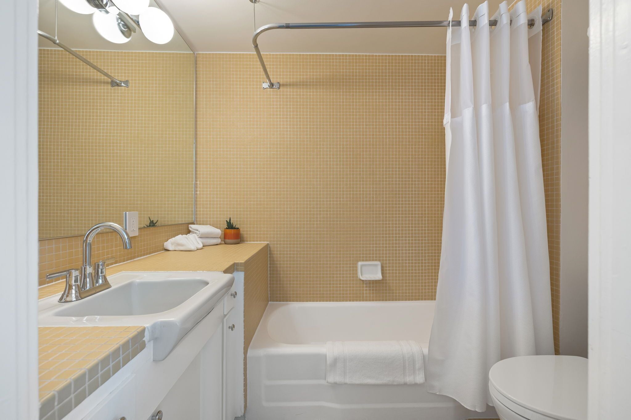 Ein Badezimmer mit Badewanne, Waschbecken, Toilette und Duschvorhang.