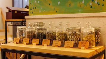 A tea display with various types of tea in glass jars labeled with names like 'Sporis Tea', 'Sipsuk Tea', and 'Thyme Tea'.