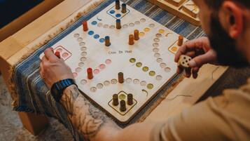 Een houten bordspel met een rasterpatroon en diverse gekleurde stukken, wat een strategisch spel aangeeft.