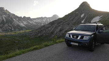 Un SUV Nissan estacionado en una carretera, con un paisaje montañoso al fondo.