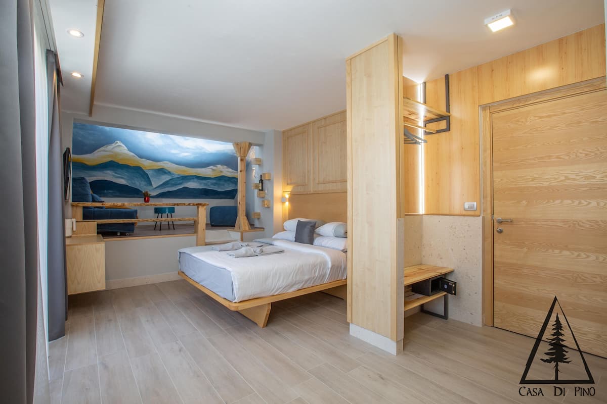 Une chambre à coucher moderne avec un lit, un bureau et un tableau accroché au mur.