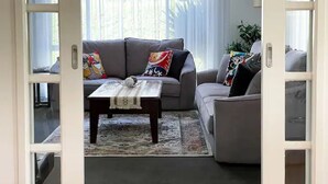 Un salon avec un canapé gris, une table basse et un tapis à motifs.