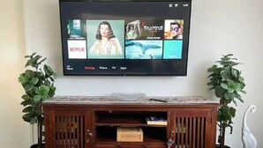 Un meuble de rangement en bois abritant un téléviseur à écran plat diffusant Netflix, HBO et d’autres services de diffusion en continu.