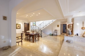 A spacious living area with a dining table, chairs, a staircase, and a reception desk. - Modern Villa for 8 people with large pool and barbecue (Inca)