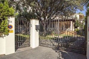A gated entrance with a metal gate, a no parking sign, and a building with a tiled roof and columns. - Modern Villa for 8 people with large pool and barbecue (Inca)