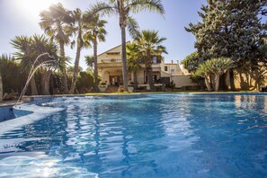 A swimming pool with palm trees and a building in the background. - Modern Villa for 8 people with large pool and barbecue (Inca)