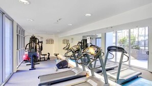 A gym with treadmills, elliptical machines, and weightlifting equipment. - Executive Family Suite View Parking WiFi (Brisbane)