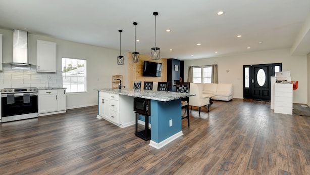 A spacious kitchen with a central island, built-in appliances, and a dining area with a sofa. - CG Suites (Columbus)