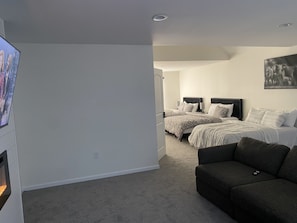 Une chambre avec deux lits, une télévision et un canapé.