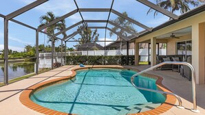 A covered swimming pool with a patio area, a view of the surrounding landscape, and a covered seating area.
