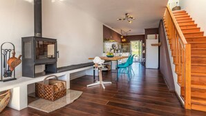 A modern kitchen with a central island, wooden flooring, and a staircase on the right. - Rooftop Terrace Apartment - Beach House Clerigo by Lisbeyond (Aljezur)