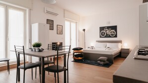 A modern, well-lit room with a bed, bedside table, lamp, and a bicycle-themed artwork on the wall. - Brombeis by Casa Napoletana, with patio H. center (Napoli)
