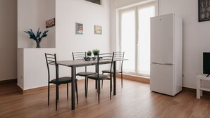 A modern kitchen with a dining table, chairs, a refrigerator, and a window. - Brombeis by Casa Napoletana, with patio H. center (Napoli)
