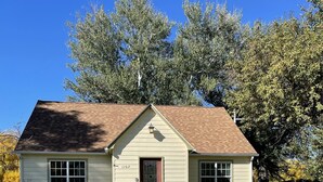 A single-story house with a front porch, a red door, and a mailbox. - Come stay at Suzie's House!<br>Spacious Family-Friendly 4-Bedroom Home (Fort Benton)