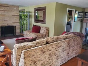 A living room with a sofa, a fireplace, and a mirror on the wall.