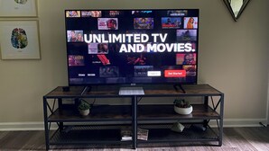 A television on a wooden stand with a screen displaying a streaming service interface. - Marines peaceful retreat, The Spiral @ AbbeyAcres Near Beach with Washer & Dryer (Holly Ridge)